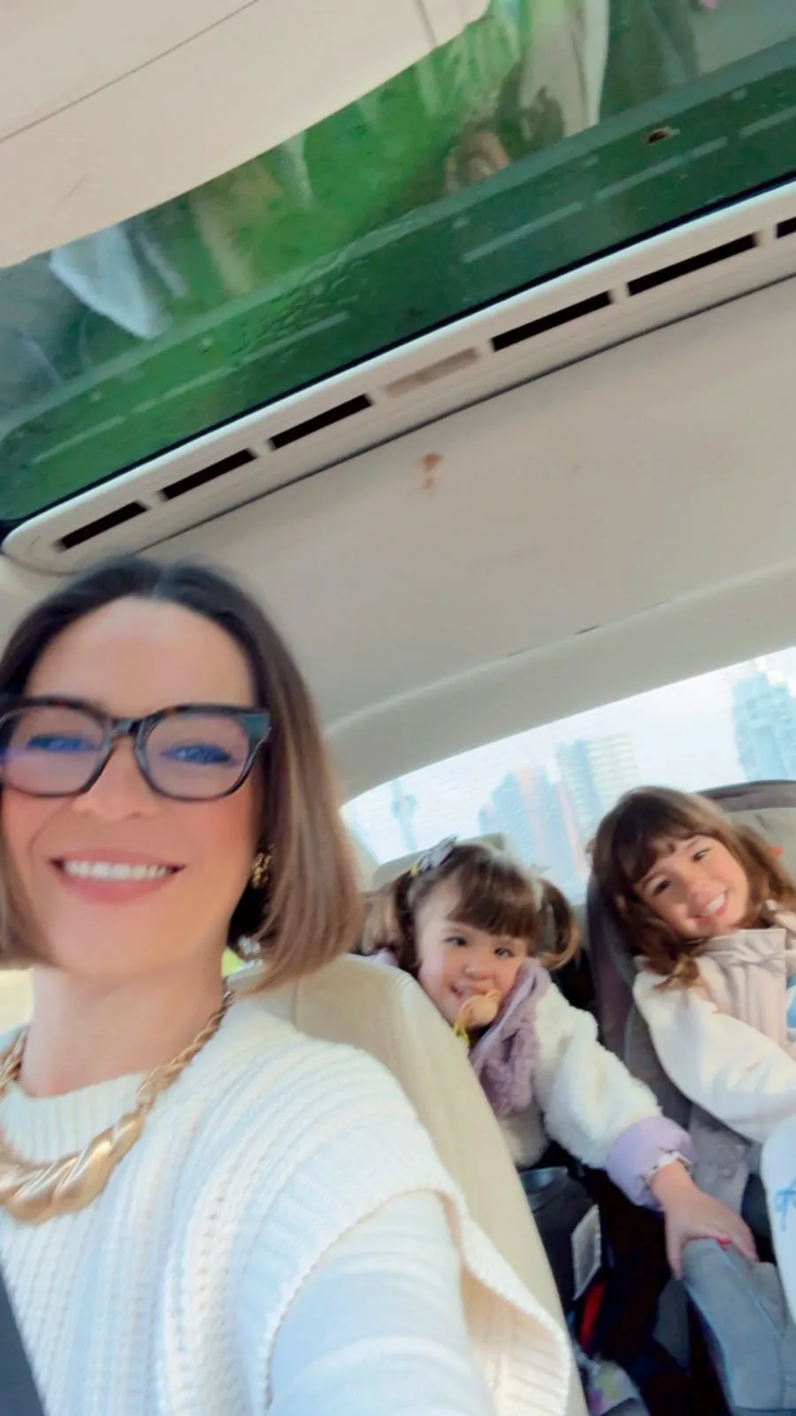Nicole com as duas filhas dentro do carro